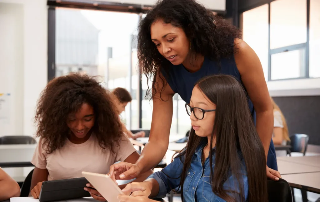 teacher giving students assignment to complete on phones 