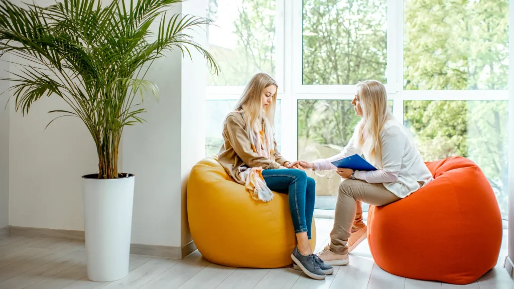 counsellor sitting with female student in a quiet well-lit natural calm place 