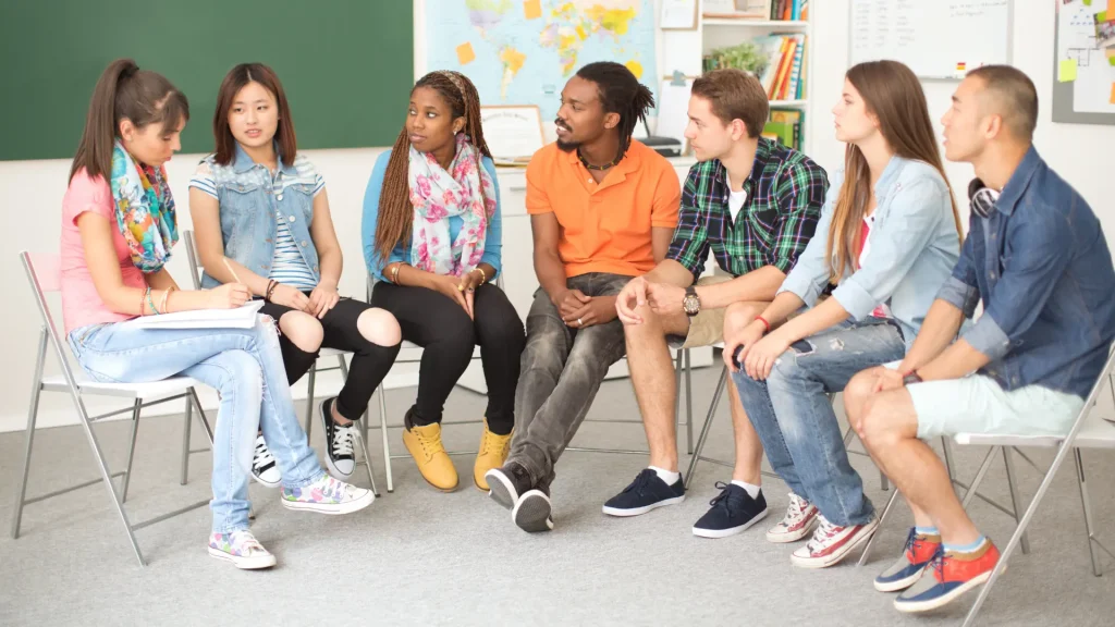 students in class (high school level) talking with teacher in circle
